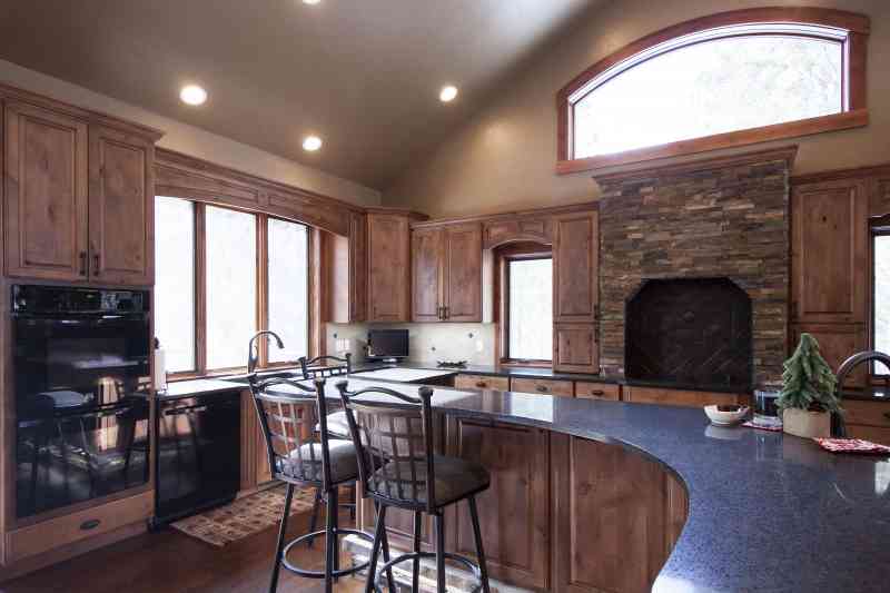 The island curves through the kitchen. It has seating on one side and prep space on the other.