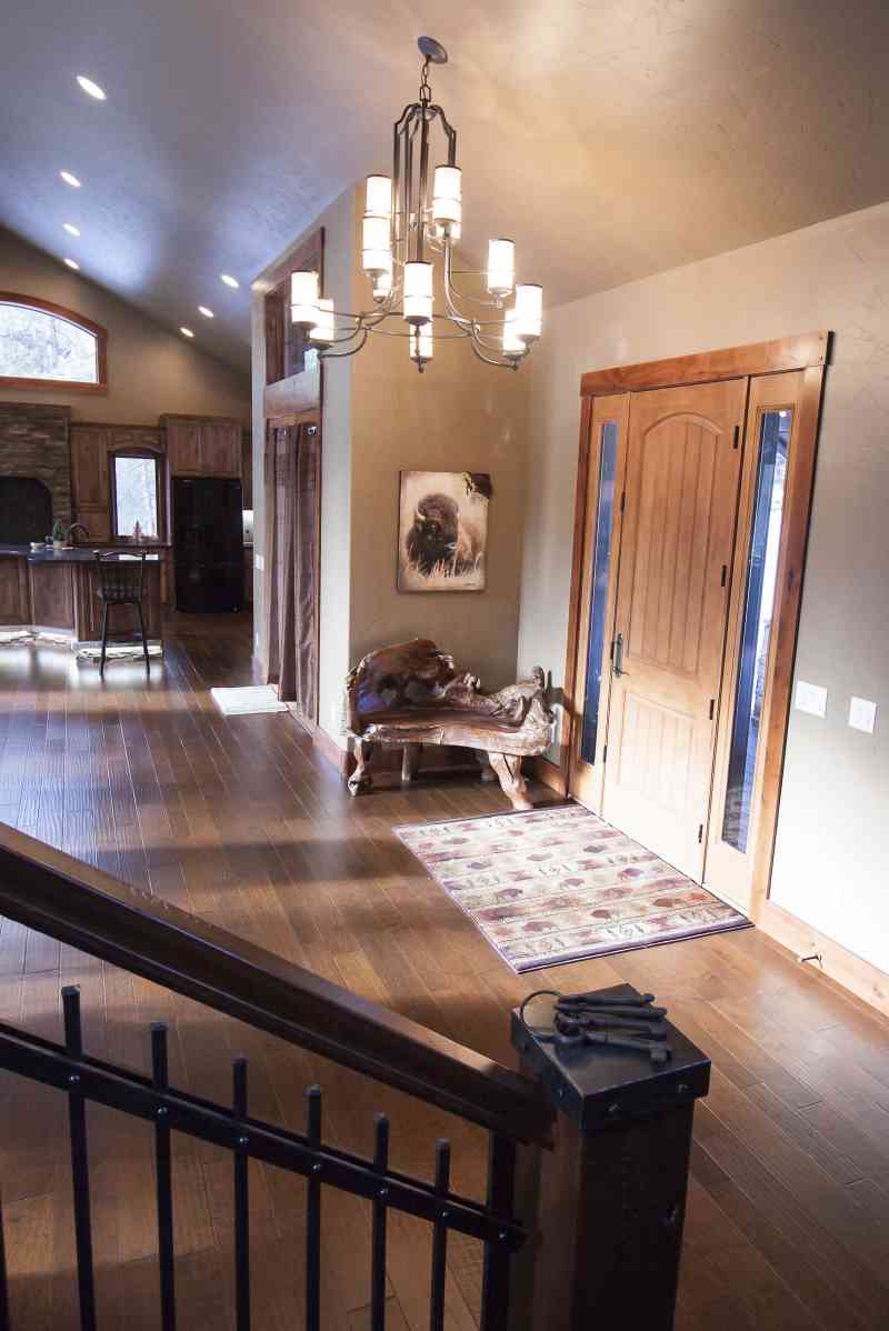 A rustic, carved wooden chair welcomes guests into the foyer.