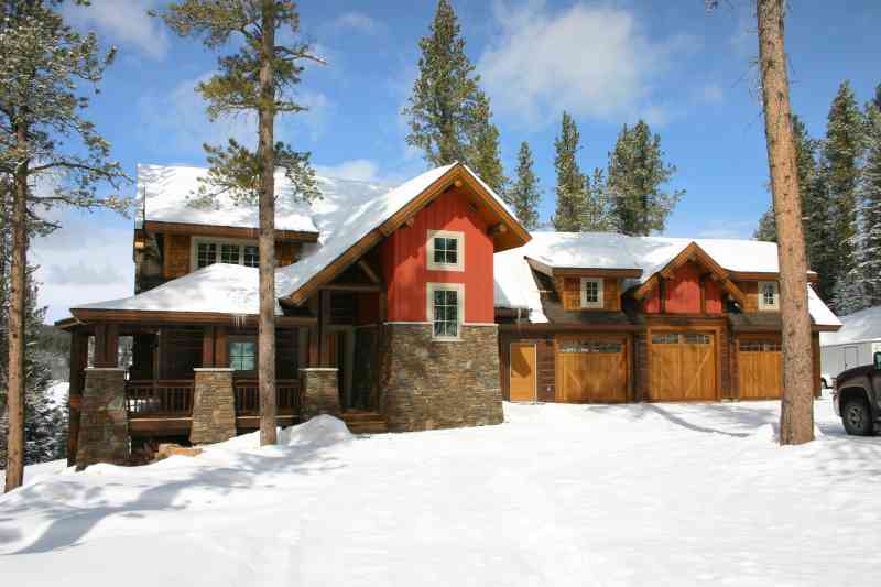 Gorgeous, wooden garage doors are the focal point of the back view of this home.