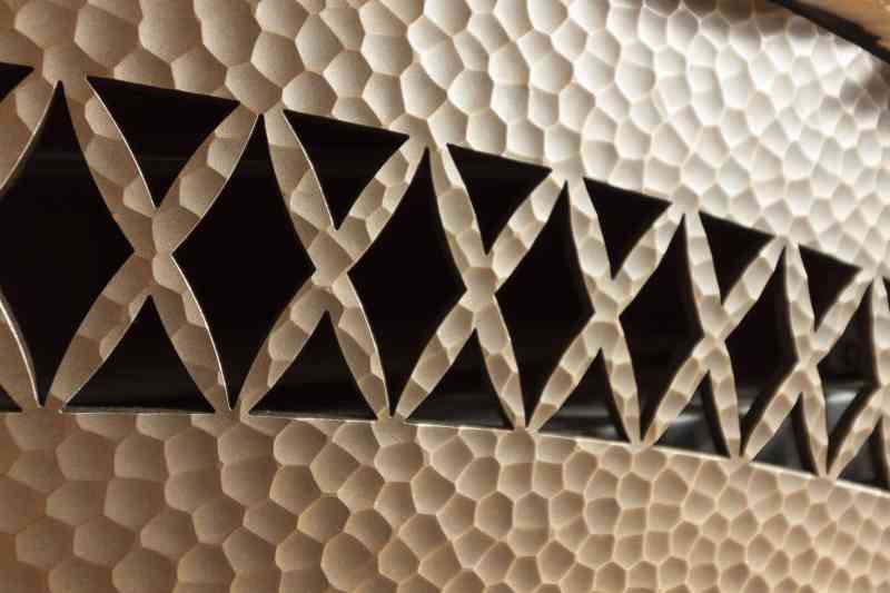 This hammered-metal fireplace cover fits in well with this rustic home!