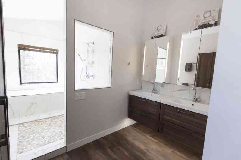 A glass opening in the bathroom brings in the natural light from the shower room's window.