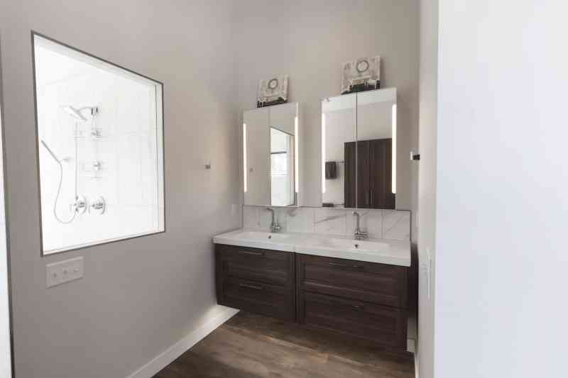 Modern, floating vanities in the master bath with built-in lighting.