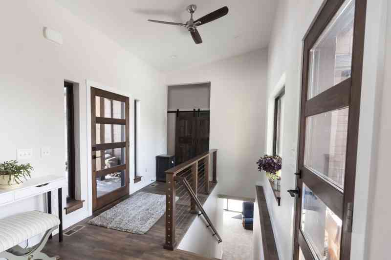 The house's main entrance is lit well with natural light from the large hallway windows.